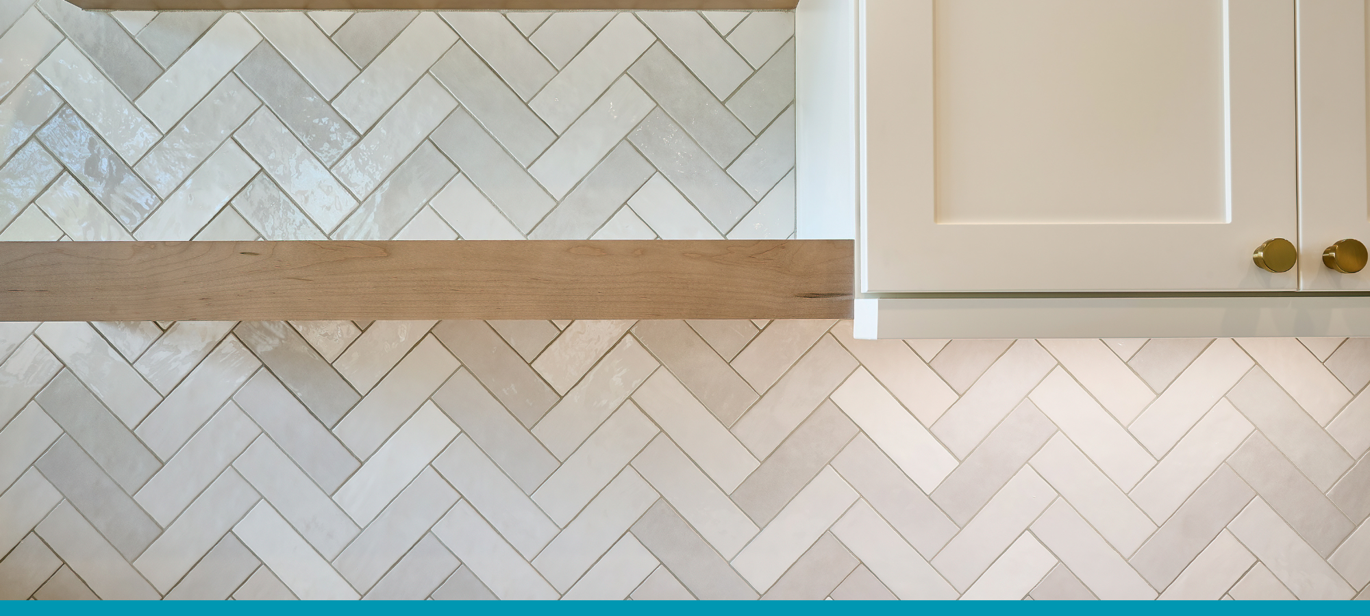 White herringbone tile backsplash extending to the ceiling in a modern kitchen with white cabinets.